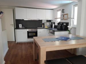 a kitchen with white cabinets and a wooden table at Ferienhaus Nr. 10 in Buergstadt