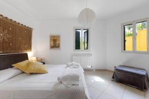 a white bedroom with a large bed and two windows at Appartamento Venere in villa 15pax in Marina di Ragusa