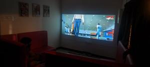 a living room with a flat screen tv on a wall at COCHIN CINEMA Rooms in Cochin