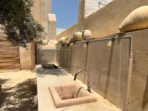 two birds sitting on the side of a building with a sink at Dar Younes in Houmt Souk +25 photos