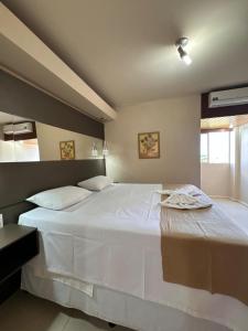 a large white bed in a room with a window at Hotel Veredas in Paracatu +72 photos
