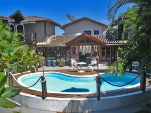 a swimming pool in front of a house at Pousada Praia da Baleia in Baleia