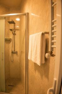 a shower with a glass door and a towel at VELOR Hotel apartment in Batumi +48 photos