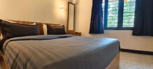 a bedroom with a bed with blue sheets and windows at COCHIN CINEMA Rooms in Cochin +16 photos