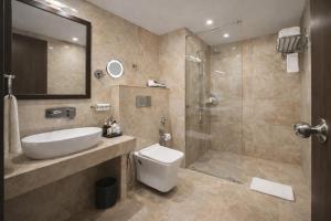 a bathroom with a toilet and a sink and a shower at Hotel Luxury Inn Delhi Airport in New Delhi +66 photos