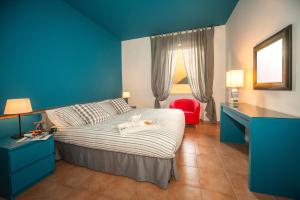 1 dormitorio azul con 1 cama y 1 silla roja en Casa Dante, en Sale Marasino