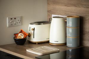 two toasters sitting on a wooden counter top at Birch Tree Lodge - Luxurious Lodge on the NC500 by Thrumster Lodges in Wick