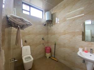 a bathroom with a toilet and a sink at Hotel Vasant - Premium Hotel in Gajraula - All AC Rooms with Restaurant - Free Wi-fi & Parking - Banquet in Gajraula +16 photos