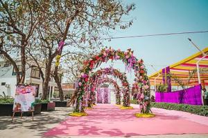 an arch with flowers on a pink carpet at Hotel Vasant - Premium Hotel in Gajraula - All AC Rooms with Restaurant - Free Wi-fi & Parking - Banquet in Gajraula