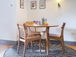 a dining room table with two chairs and a wooden table at Lee Cottage - E4343A in Holy Island