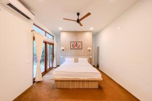 a bedroom with a bed and a ceiling fan at Aavaranaa Farmstay in Kanakapura