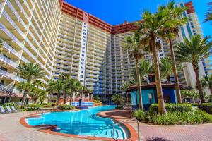 a resort with a swimming pool and palm trees at Shores of Panama Resort in Panama City Beach