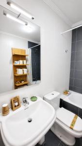 a white bathroom with a sink and a toilet at CAROLA l, "Encantador apartamento de estilo marinero a 100m playa Catia" in Ribeira +24 photos