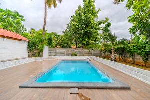 a swimming pool on a wooden deck next to a house at Aavaranaa Farmstay in Kanakapura +59 photos