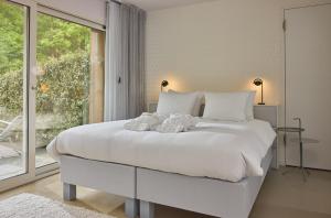 een witte slaapkamer met een groot bed en een raam bij blooming in Bergen