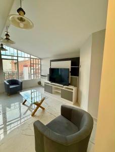 a living room with a tv and a couch and a table at Premium House in Comodoro Rivadavia
