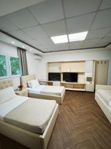 a hotel room with two beds and a flat screen tv at Hotel Legjenda in Shkodër