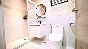 a bathroom with a toilet and a mirror at 小邱民宿 in Anping