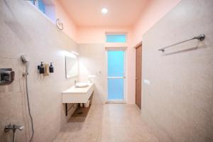 a bathroom with a sink and a shower with a window at Aavaranaa Farmstay in Kanakapura