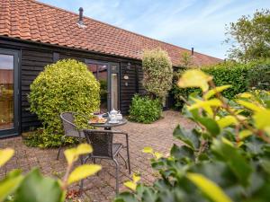 a patio with two chairs and a table at Thyme - E4485 in Catfield