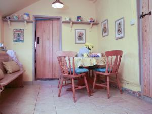 a dining room with a table and two chairs at Bell Corner Cottage in Cratfield