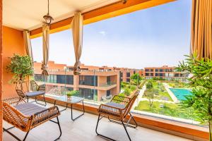 a balcony with chairs and a table and a large window at Appartement Noria Golf in El Makina