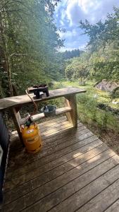 a picnic table with a camera and a bag on it at Idylisk primitiv hytte midt i skoven in Them +8 photos