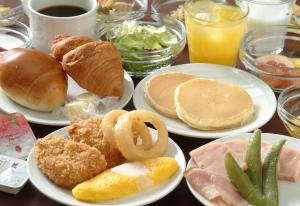 a table with plates of breakfast food on it at Dormy Inn Kumamoto Natural Hot Spring in Kumamoto