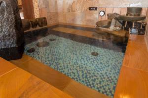 a bathroom with a pool of water on the floor at Dormy Inn Kumamoto Natural Hot Spring in Kumamoto