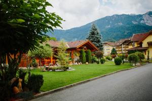 a resort with a green lawn in front of a mountain at Hotel Garni Zerza in Tröpolach