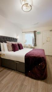 a bedroom with a large bed with purple pillows at Kildare House Hotel in Kildare +110 photos