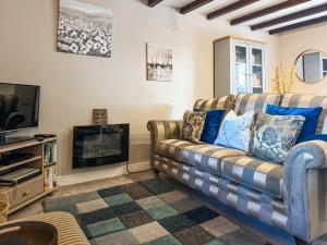 a living room with a couch and a tv at The Old Barn-E1425 in Addlethorpe