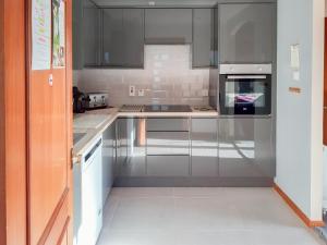 a kitchen with stainless steel appliances and gray cabinets at Park Lodge in Strachan