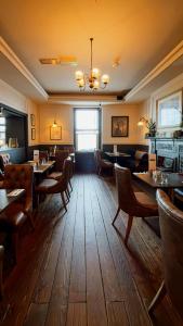 a restaurant with wooden floors and tables and chairs at Kildare House Hotel in Kildare