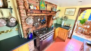 a kitchen with a brick wall and a stove at River Views, Private Fishing & 9 min Train to York in Ulleskelf