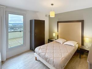 a bedroom with a large bed and a large window at Terres de France - Appart Hôtel Rouen Flaubert in Rouen +49 photos