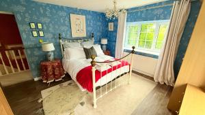 a bedroom with blue walls and a bed with a red blanket at River Views, Private Fishing & 9 min Train to York in Ulleskelf