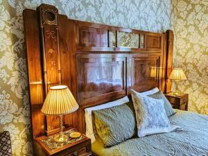a bedroom with a bed with a wooden head board at The Gables in Duddo