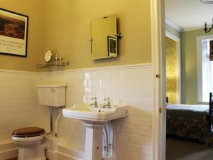 a bathroom with a sink and a toilet and a mirror at The Gables in Duddo