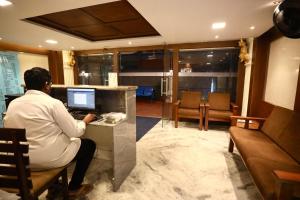 a man sitting at a desk working on a computer at StarlightHotels ARResidency in Chennai