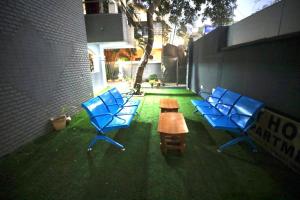 a group of blue chairs and a table on the grass at StarlightHotels ARResidency in Chennai