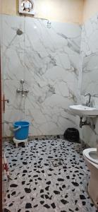 a bathroom with a black and white tiled floor at Krishna's land Homestay in Vrindāvan