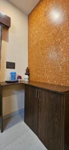 a kitchen with a counter and a gold wall at Krishna's land Homestay in Vrindāvan