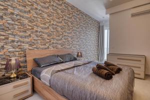 a bedroom with a brick wall and a bed at St Julian s Luxury Laura Apartments in Is-Swieqi