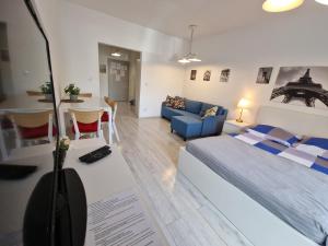 a bedroom with a bed and a living room at Luxury in City -3- Studio Bright & Secure Free Parking in Łódź
