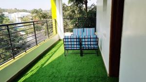 two chairs sitting on a balcony with green flooring at GRANADA HOTEL NAIROBi in Nairobi