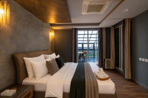 a hotel room with a large bed and a window at Gold Crest Signature Boutique Apartments With City Views -DHA PHASE 4 LAHORE in Lahore +98 photos