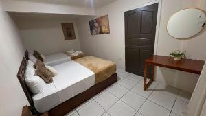 a bedroom with a bed and a mirror and a table at Basecamp Monteverde in Monteverde Costa Rica