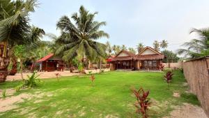 a resort with palm trees and a large yard at Bintang Left Homestay Mentawai in Katiet
