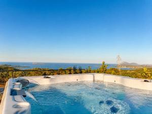 a hot tub with a view of the ocean at Villa Ottavio Costa Smeralda View 360 in San Pantaleo